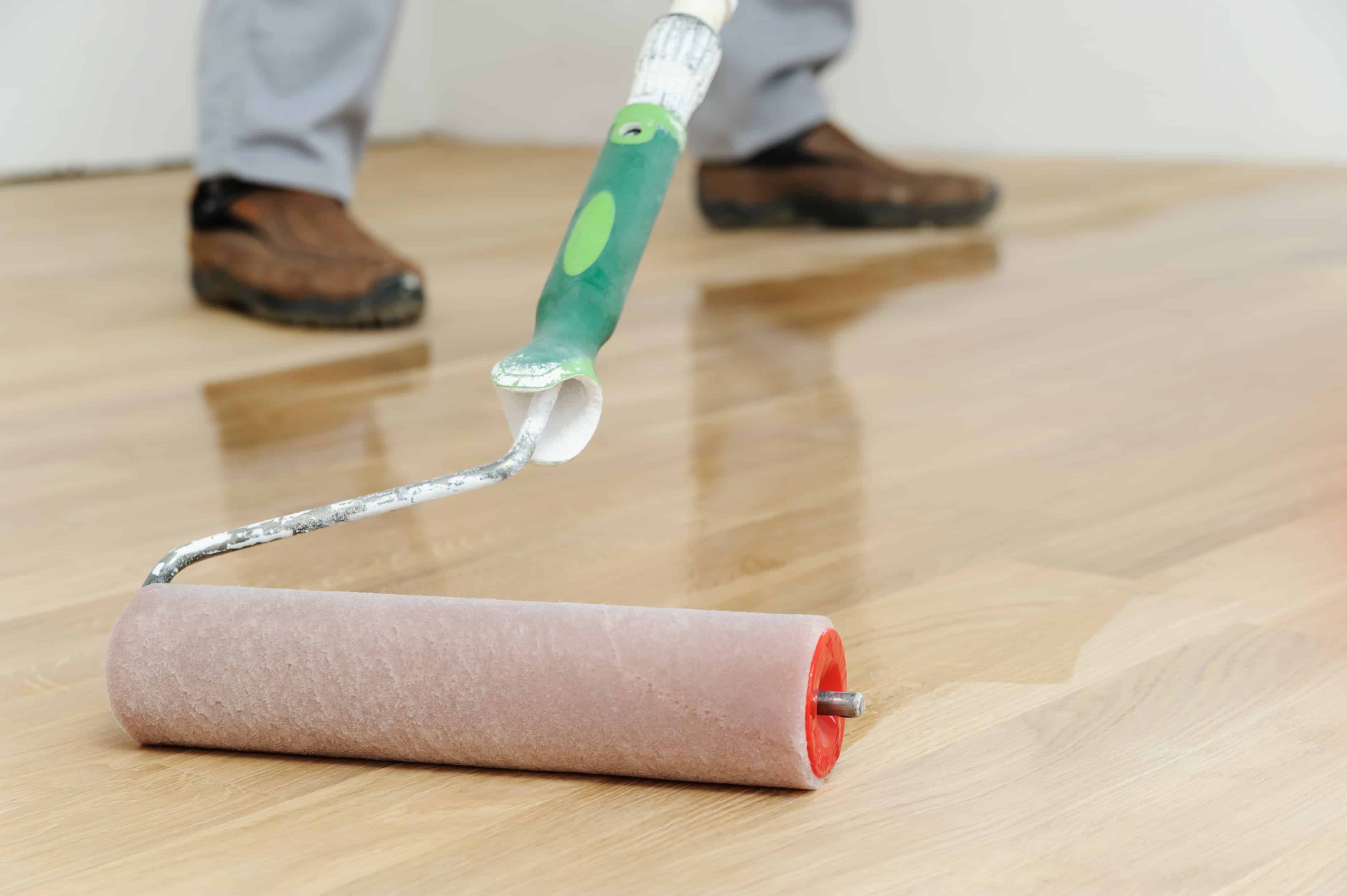 Lacquering wood floors. Use roller for coating floors.