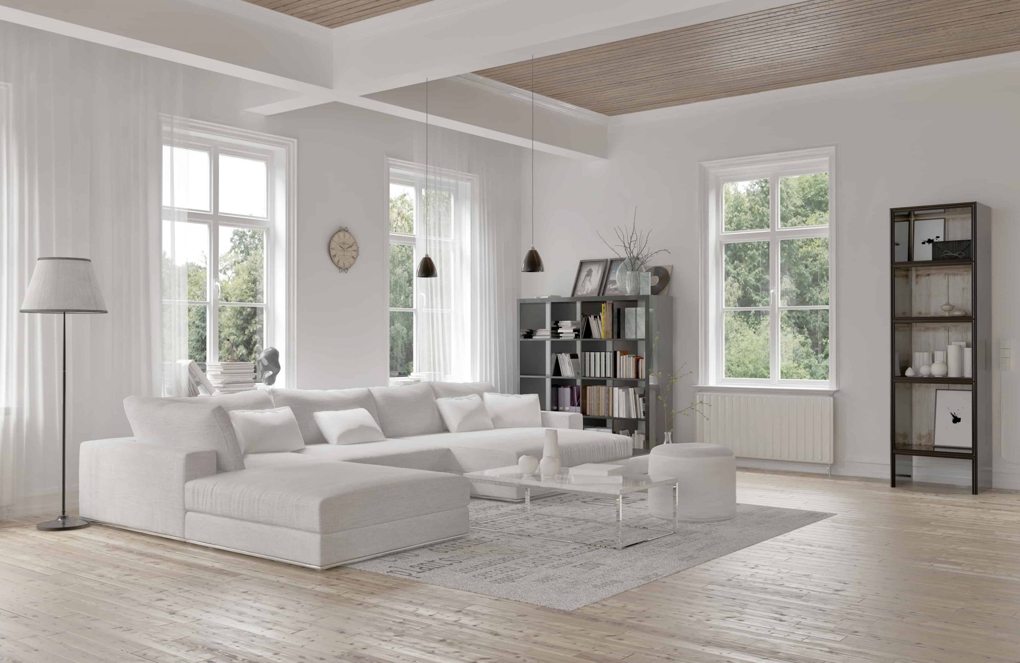 Modern loft living room interior with monochromatic white decor, a comfortable modular lounge suite and rug and accent bookcases with structural ceiling beams